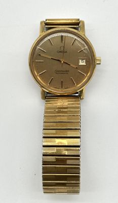 a close up of a gold wrist watch on a white surface