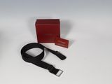 an open red box with a black belt and a red box with a red tag