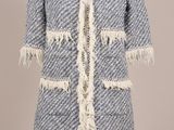 un manteau bleu et blanc à franges sur un mannequin