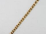 a close up of a gold bracelet on a white surface