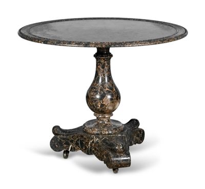 une table ronde avec un piètement en métal et un plateau en marbre
