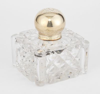 un gros plan d'un flacon de parfum en verre transparent muni d'un bouchon doré