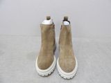 the back view of a pair of tan sued boots with white soles
