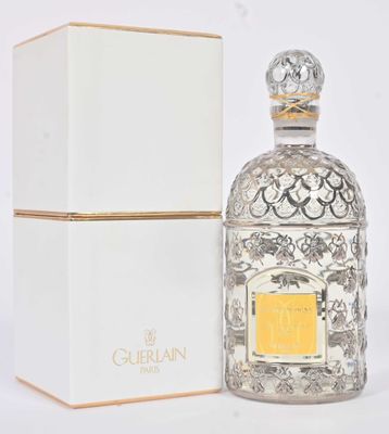 l'image d'un flacon de parfum posé à côté d'une boîte