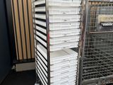 several trays of food are stacked on a cart in front of a wall
