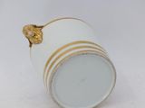an image of a white and gold cup on a white surface