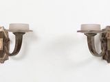 une paire d'appliques murales, chacune ornée de bougies, sur un mur blanc