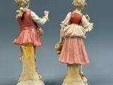 paire de figurines en porcelaine représentant une fille et un garçon accompagnés d'un oiseau