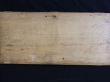 an old wooden cutting board sitting on top of a black table