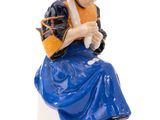a figurine of a woman sitting on a toilet