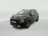 Une Citroën noire est garée dans une pièce blanche