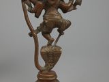 an image of a bronze statue of a person on a tree branch