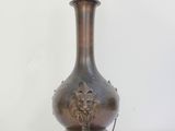 a large bronze vase with a lion head on it