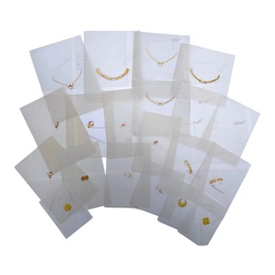 a lot of white bags with gold jewelry on them