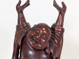 an image of a statue of a laughing buddha sitting on a white surface