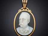 un portrait en marbre blanc représentant un homme portant un nœud papillon, dans un cadre doré
