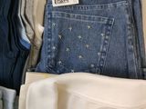 several pairs of jeans are stacked on top of each other