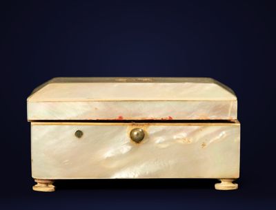 une boîte blanche avec une poignée dorée sur fond bleu