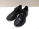 pair of black soccer shoes sitting on top of a white table