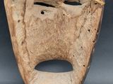 an image of a wooden mask with a rope around it