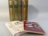 three books sitting on top of a white table next to each other