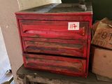 une boîte à outils rouge posée sur une table en bois