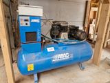 un compresseur d'air bleu posé dans un garage, avec un réservoir bleu