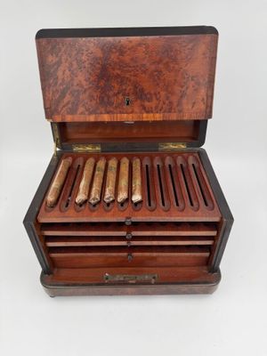une boîte de cigares ouverte posée sur une surface blanche