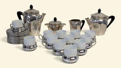 une photo d'un service à café en argent avec des tasses et des soucoupes