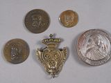 five coins and a medal on a table next to a coin
