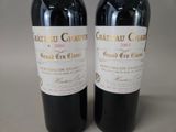 two bottles of red wine sitting next to each other on a table