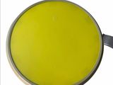 a pan with a yellow liquid in it on a white surface
