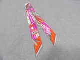 orange and white floral neck tie on a gray background