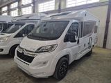 trois camping-cars blancs garés dans un entrepôt avec d'autres véhicules