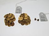 deux paires de boucles d'oreilles en or et une étiquette de prix posée sur une table blanche