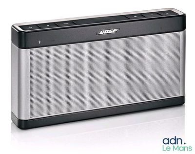 un gros plan d'une enceinte Bluetooth posée sur une surface blanche