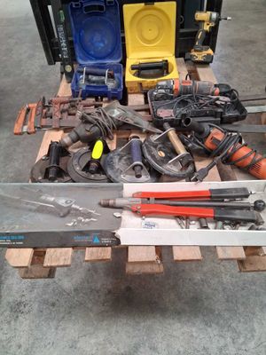 a pile of tools sitting on a pallet in a garage