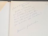 a handwritten note in a book with a pen on it