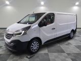 la camionnette blanche est garée sur un sol carrelé en damier