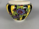 an image of a black and yellow bowl with grapes on it