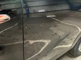 a person standing next to a car in a garage