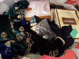 a bag full of clothing and a book on a bed