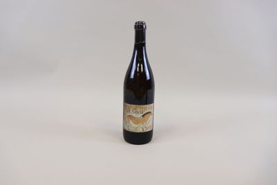 La bouteille de bière est posée sur une surface blanche.