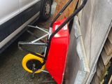 un petit chariot garé à côté d'une camionnette blanche