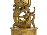 une image représentant une statue en or d'une femme tenant une horloge