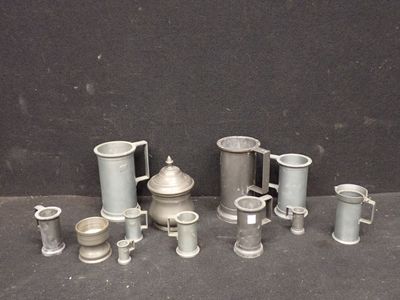 de nombreuses tasses et mugs en argent posés sur une table