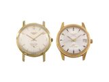 pair of gold tone wrist watches with white dials on a white background