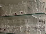 une étagère en verre sur laquelle sont posés de nombreux verres