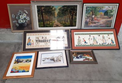 de nombreux tableaux encadrés posés par terre près d'un mur rouge