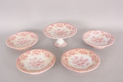 four pink and white plates with pink flowers on them on a table